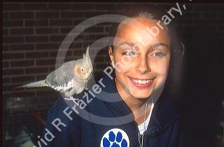 Girl with pet bird on her shoulder.  MR