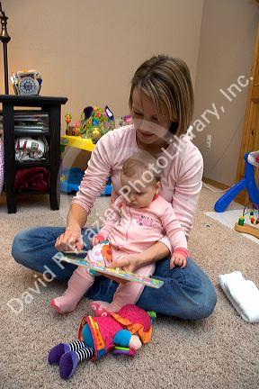 A mother and her infant child playing with toys. MR