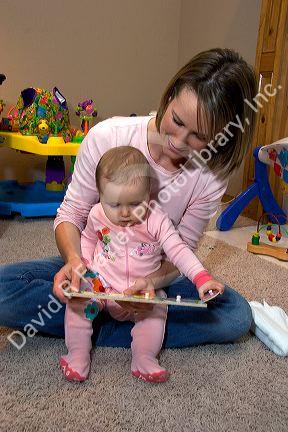 A mother and her infant child playing with toys. MR