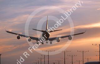 Boeing 747 landing at sunset at LAX airport in Los Angeles, California.