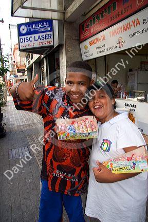 Boys selling candy on the street in the Liberdade asian section of Sao Paulo, Brazil.