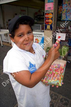 A boy selling candy on the street in the Liberdade asian section of Sao Paulo, Brazil.