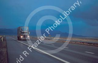 Long haul truck traveling on Interstate 80 west of Winnemucca, Nevada with approaching storm at dusk.