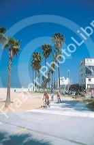 Bicyclists ride on a path along Venice Beach, California.