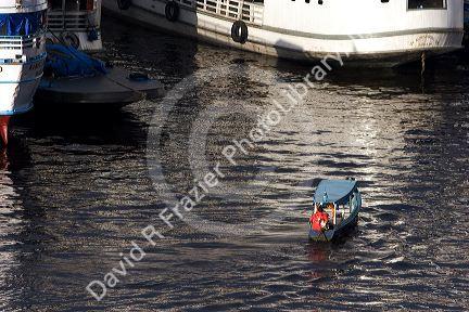 Water taxi among amazon river boats at sunrise in Manaus, Brazil.