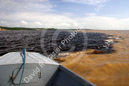 The bow of a boat at the confluence of the Amazon River and the Rio Negro at Manaus, Brazil.