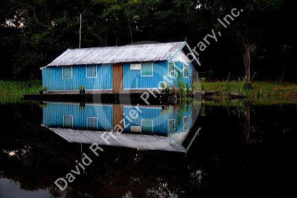 A general store reflected in the Arasa River in the Amazon jungle near Manaus, Brazil.