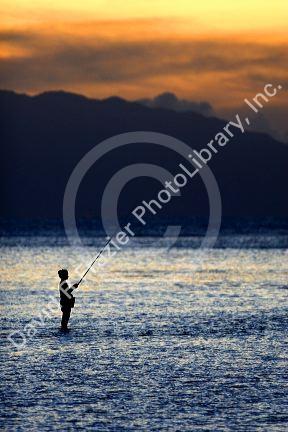 Fishing at sunset in the lagoon off the island of Tahiti.