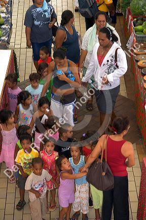 A group of young school children visit the market in Papeete on the island of Tahiti.