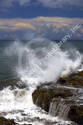 Waves crash on rocks on the island of Tahiti.