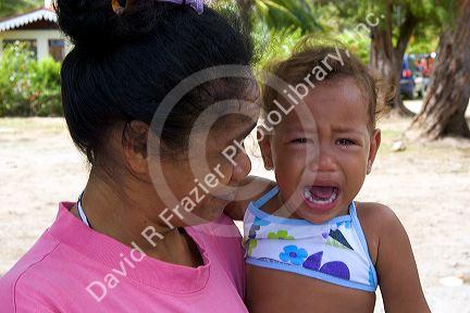 Tahitian woman with a crying child on the island of Moorea.