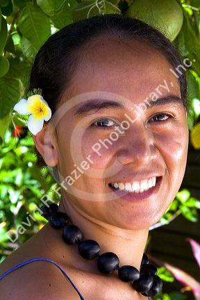 Tahitian woman wearing a plumeria flower in her hair on the island of Moorea.