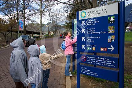 Children read a sign at the entrance to the Smithsonian National Zoological Park in Washington, D.C.
