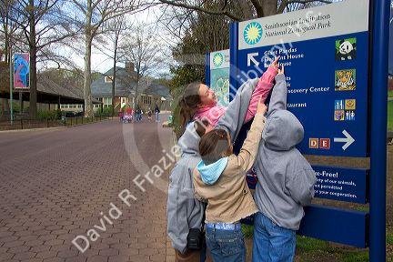 Children read a sign at the entrance to the Smithsonian National Zoologicacl Park in Washington, D.C.