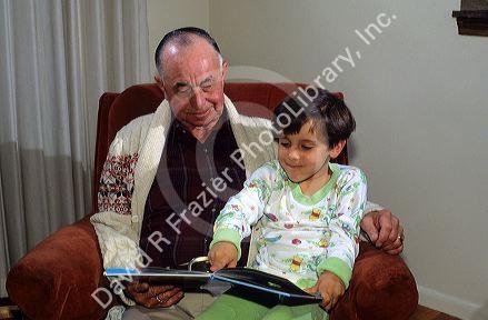 Grandfather reading to his granddaughter. MR