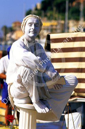 A mime painted and wearing all white in France.