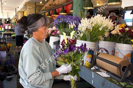 A florist arranging flowers at the Pike Place Market in Seattle, Washington.