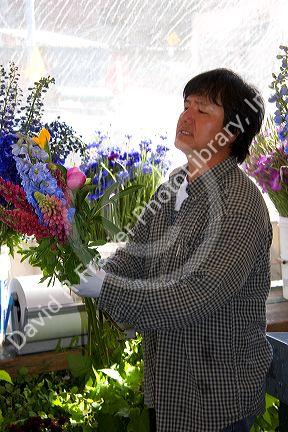 A florist arranging flowers at the Pike Place Market in Seattle, Washington.