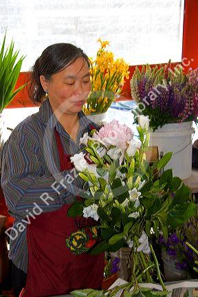 A florist arranging flowers at the Pike Place Market in Seattle, Washington.