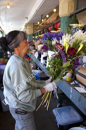 A florist arranging flowers at the Pike Place Market in Seattle, Washington.