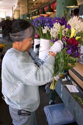 A florist arranging flowers at the Pike Place Market in Seattle, Washington.