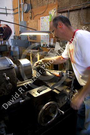 A machinist using a lathe to work on metal parts in Boise, Idaho.