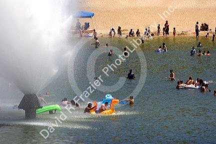 People play in a water fountain at Sandy Point recreation area near Boise, Idaho.