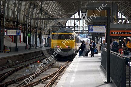 Passengers await a train at the Amsterdam Central Station, Stationsplein, Amsterdam, Netherlands.