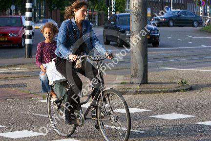 Woman and child riding on a bicycle in Amsterdam, Netherlands.