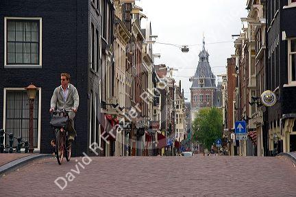 Man riding a bicycle on the street in Amsterdam, Netherlands.
