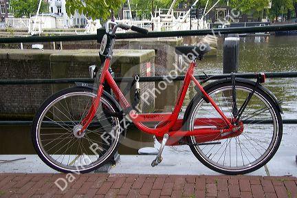 Rental bicycle parked along the Amstel River in Amsterdam, Netherlands.
