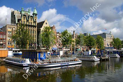 Tour canal boats on the Damrak in Amsterdam, Netherlands.