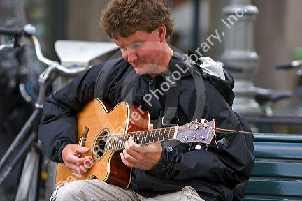 Man playing a guitar on the street in Amsterdam, Netherlands.