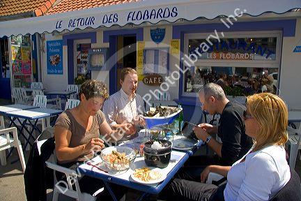 People eating seafood outdoors at a restaurant in the village of Audresselles in the department of Pas-de Calais, France.