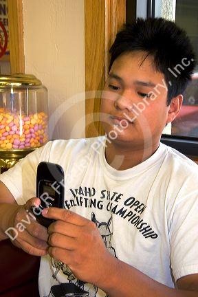 Asian man text messaging with his cell phone in Boise, Idaho.