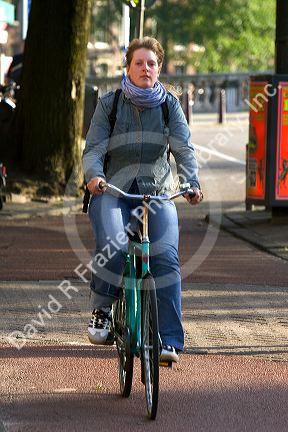 Woman riding a bicycle in Amsterdam, Netherlands.