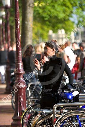 Woman using a cell phone in Amsterdam, Netherlands.