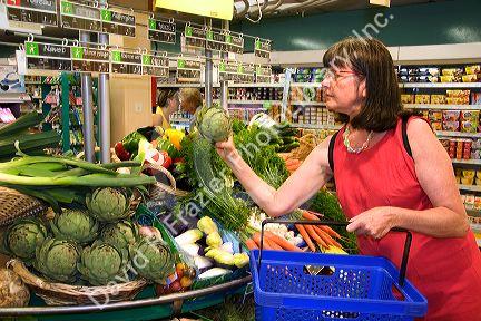 French woman shops for vegetables at a super market in the village of Barfleur in the region of Basse-Normandie, France.