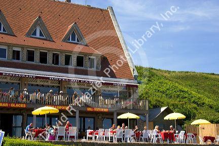 People dine outdoors at a restaurant at Omaha Beach on the coast of Normandy in northern France.