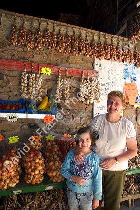 French woman and her granddaughter selling garlic at Saint-Broladre in the nation of Brittany a province of France.