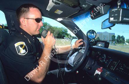 Idaho State Policeman talking on his radio in a police car.