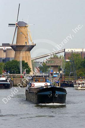 Old windmill and boats in the harbor at Rotterdam, Netherlands.
