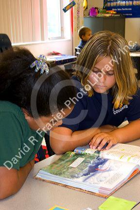 Fourth grade students read a textbook in a classroom at a public school in Tampa, Florida.