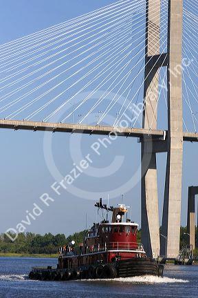 A tugboat passes under the Talmadge Memorial Bridge on the Savannah River at Savannah, Georgia.