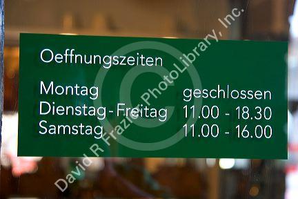 Store hours posted on door in Zurich, Switzerland.open, close, hours, store, shop, notice, sign, switzerland, swiss, language, europe, european, travel, tourism, business hours