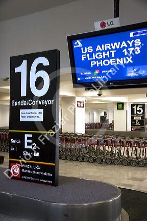 Spanish and English language signs above a baggage conveyor in the Mexico City International Airport, Mexico.