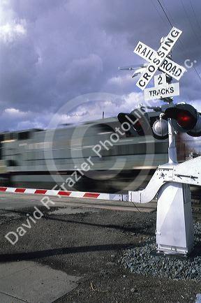 A train traveling in front of a railroad crossing sign.