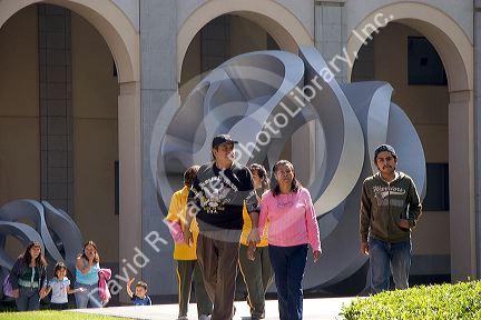People walk in front of a sculpture at the National Palace in Mexico City, Mexico.