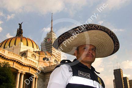 A police officer wearing a sombrero in front of the Palace of Fine Arts in Mexico City, Mexico.