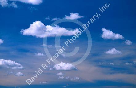 Cumulus clouds against a blue and purple sky.